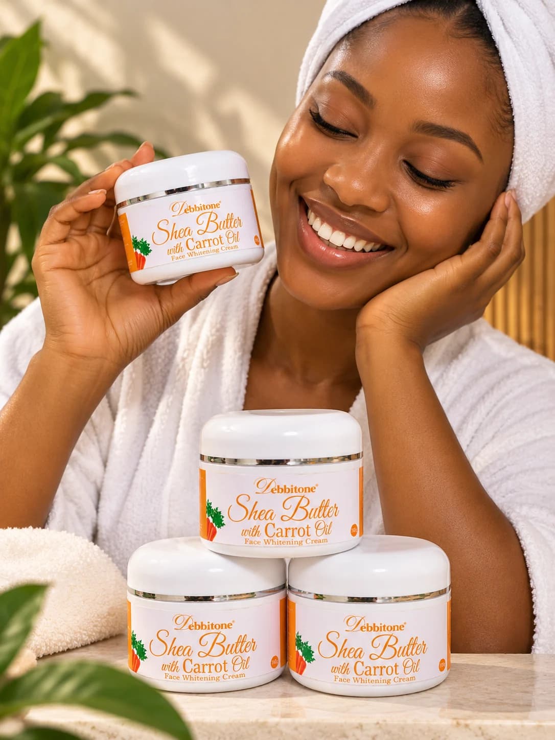 A woman smiling beside jars of Debbitone SheaButter Carrot Brightening Cream